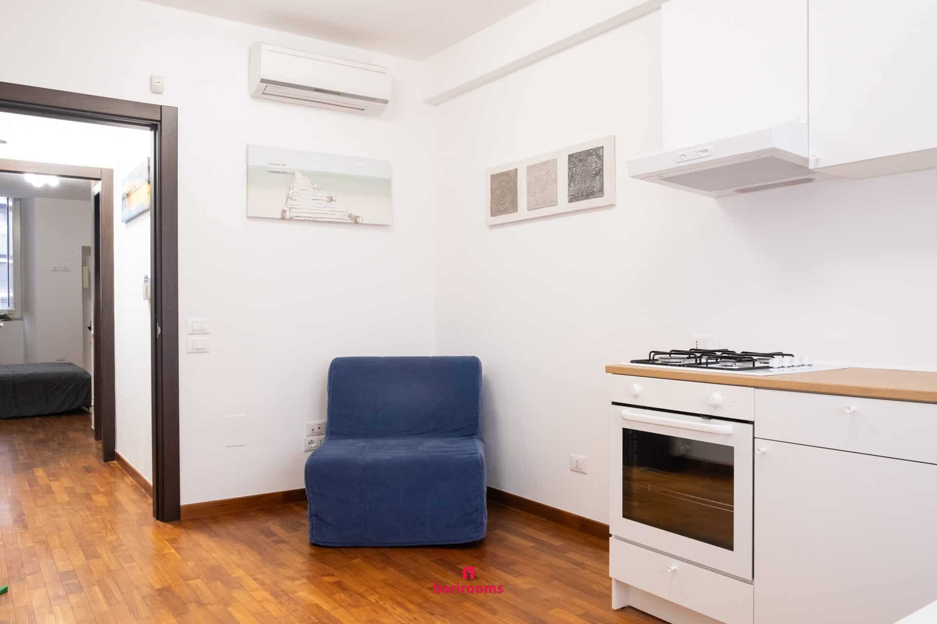 Soggiorno con poltrona letto e cucina, appartamento Maison 30 Bari