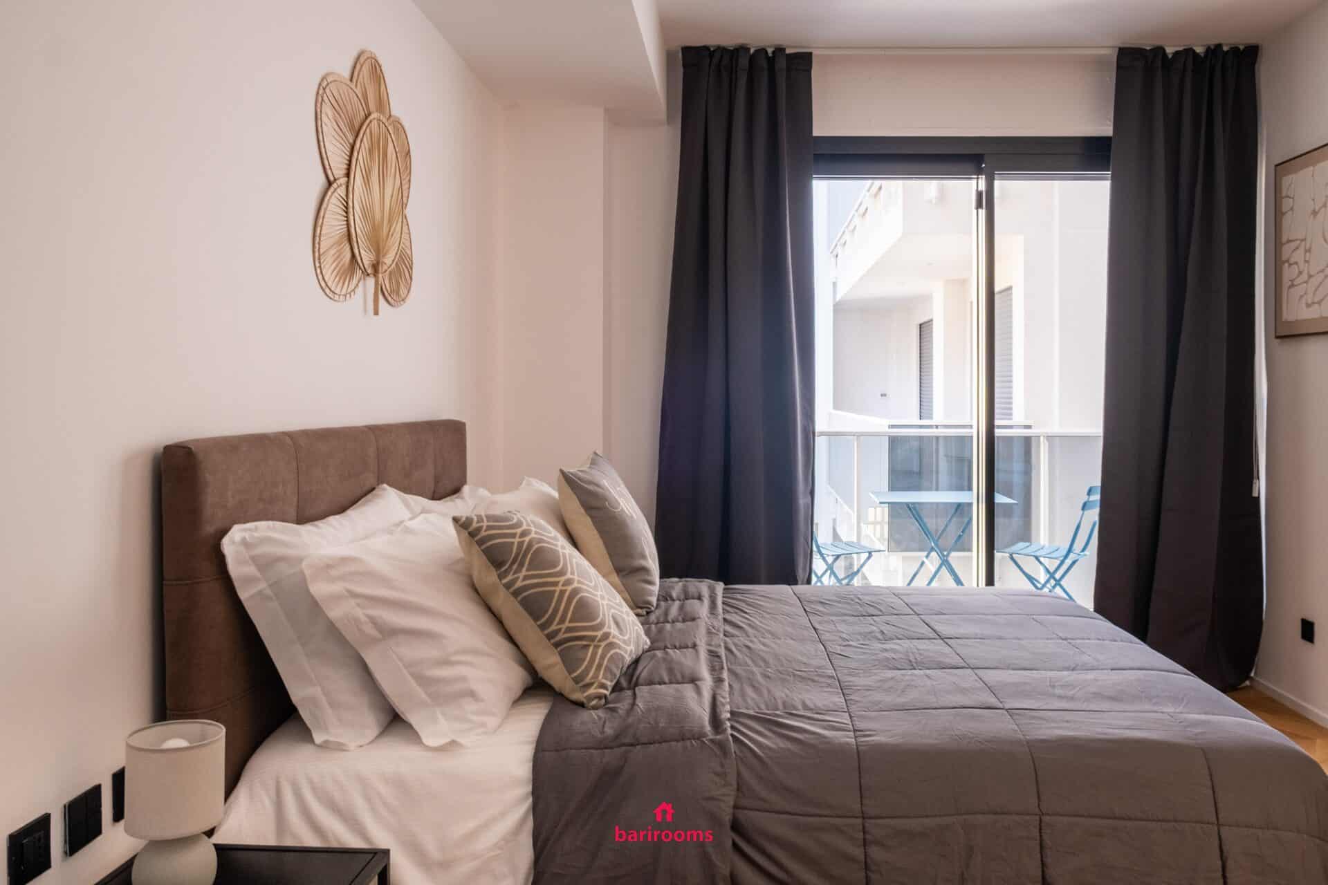 Letto matrimoniale con vista sul balcone, appartamento Metropole Bari